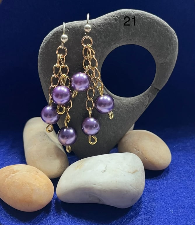 Beautiful dangling earrings on gold coloured chain with purple beads.