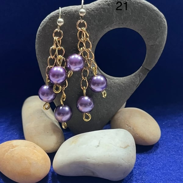 Beautiful dangling earrings on gold coloured chain with purple beads.