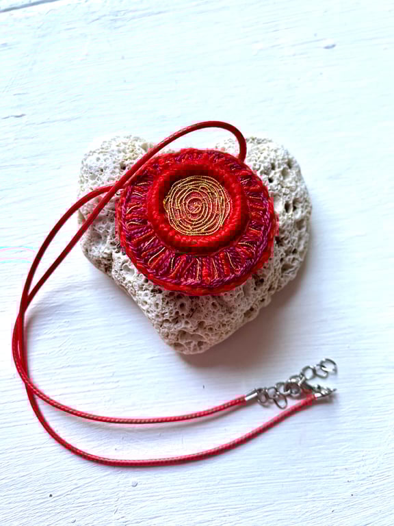 Red and gold, hand embroidered pendant intricately stitched.