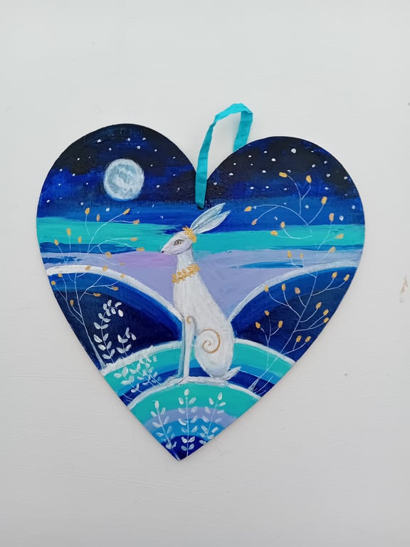 White hare golden leaves  on a wooden heart 