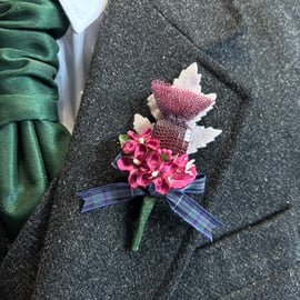 Handmade Buttonhole with a knitted wire thistle, burgundy flowers and tartan bow