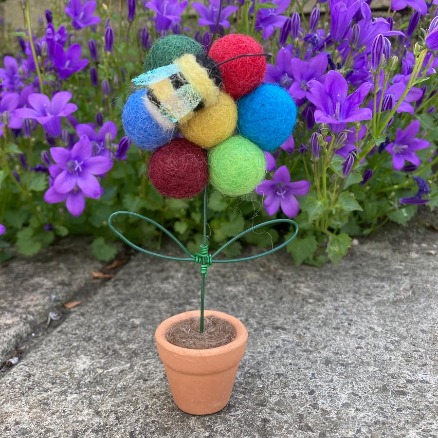 Felt ball flower in pot with bumble bee