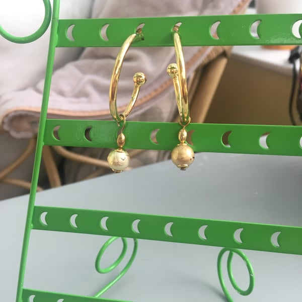 Gold tone hoop earrings with free moving gold bead