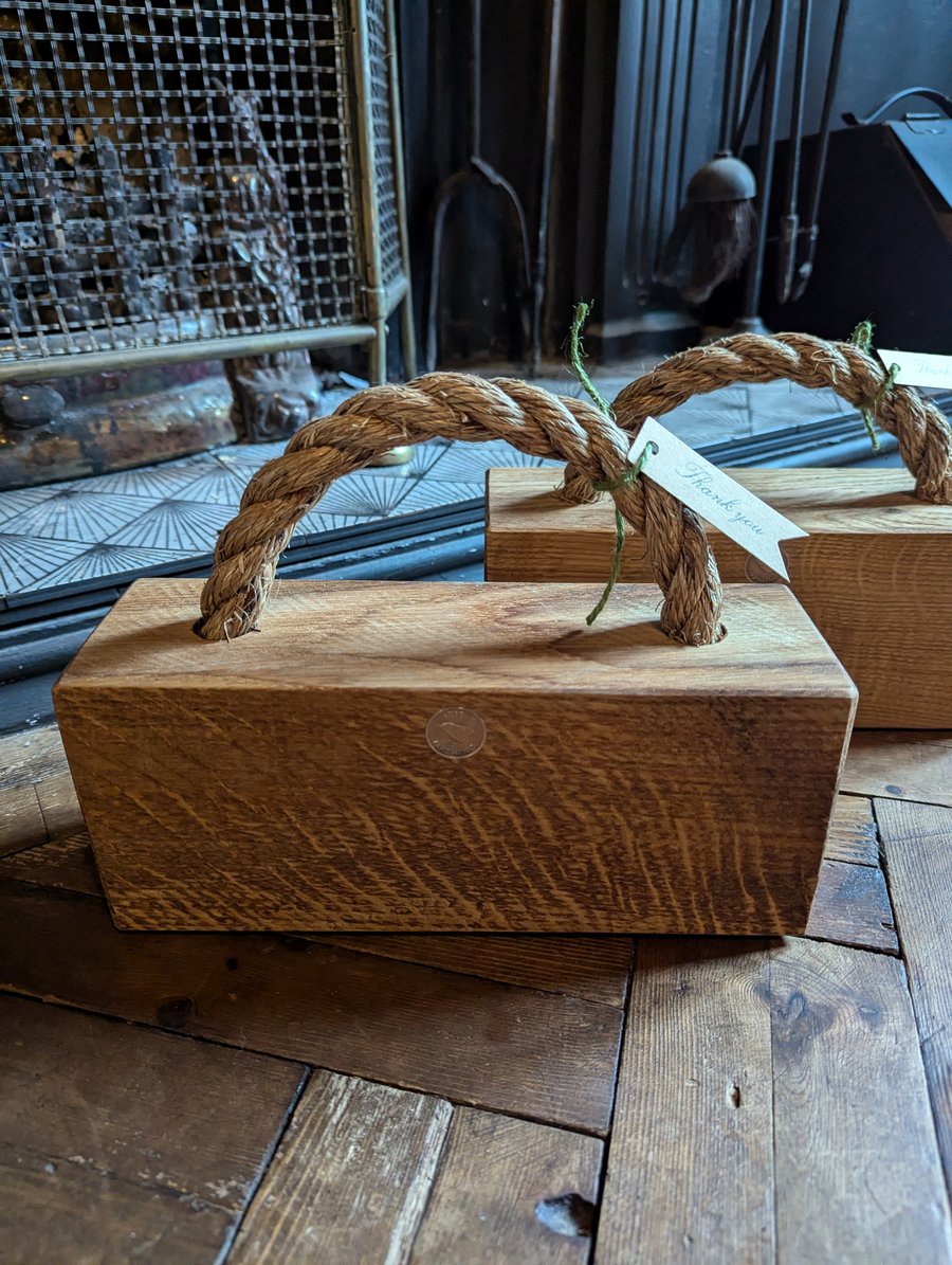 Solid oak and rope doorstop.