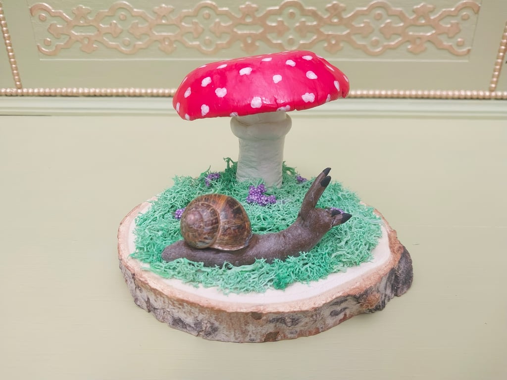 Hand painted Clay mushroom toadstool snail on a log slice woodland fairy theme