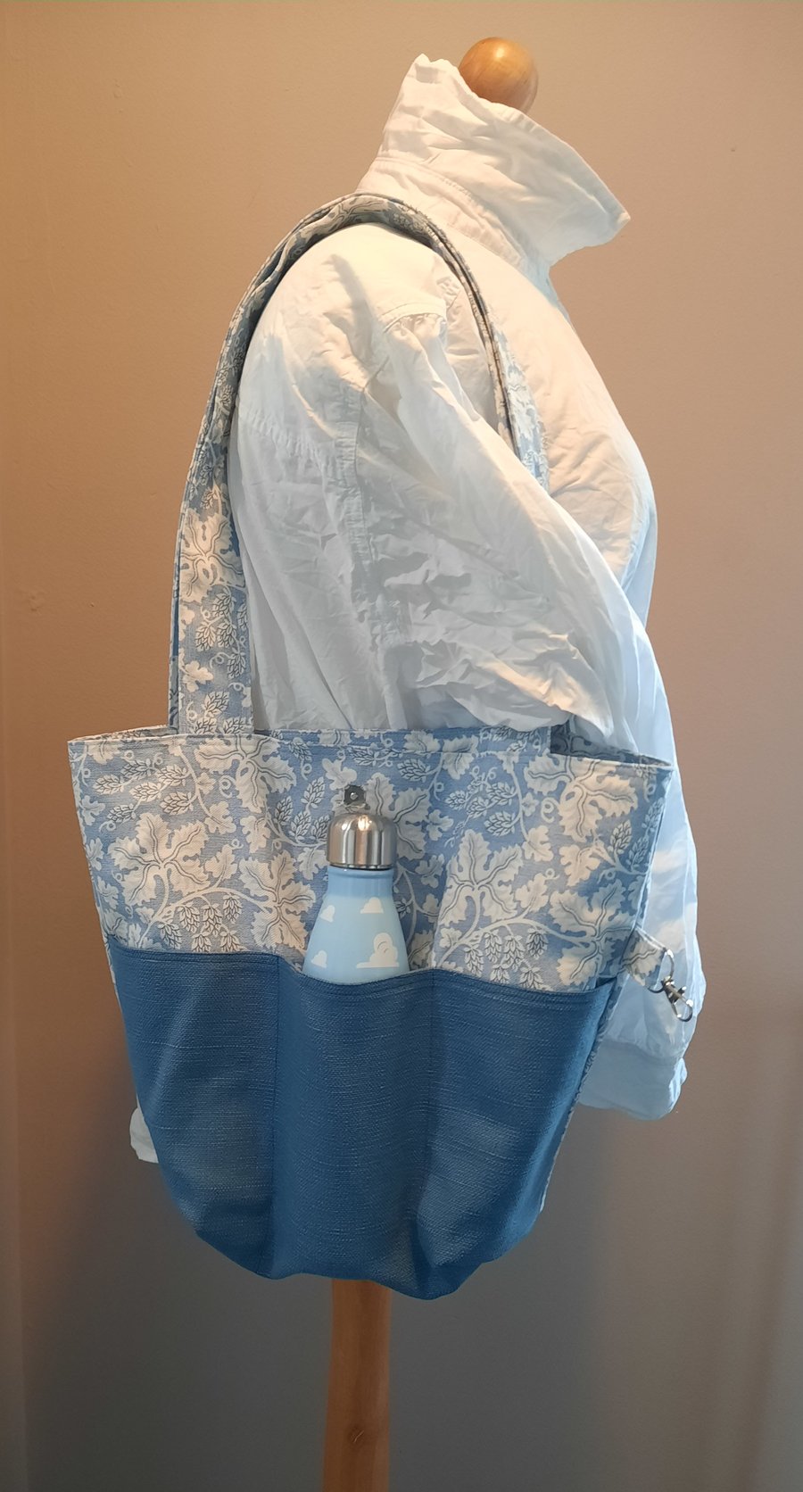 Blue tote bag with pockets and magnetic popper fastening.  