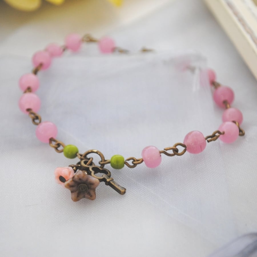 Pink bracelet with purple flower charm 