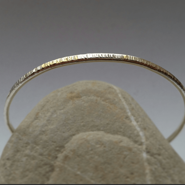 Simple textured slim silver bangle with gold accent