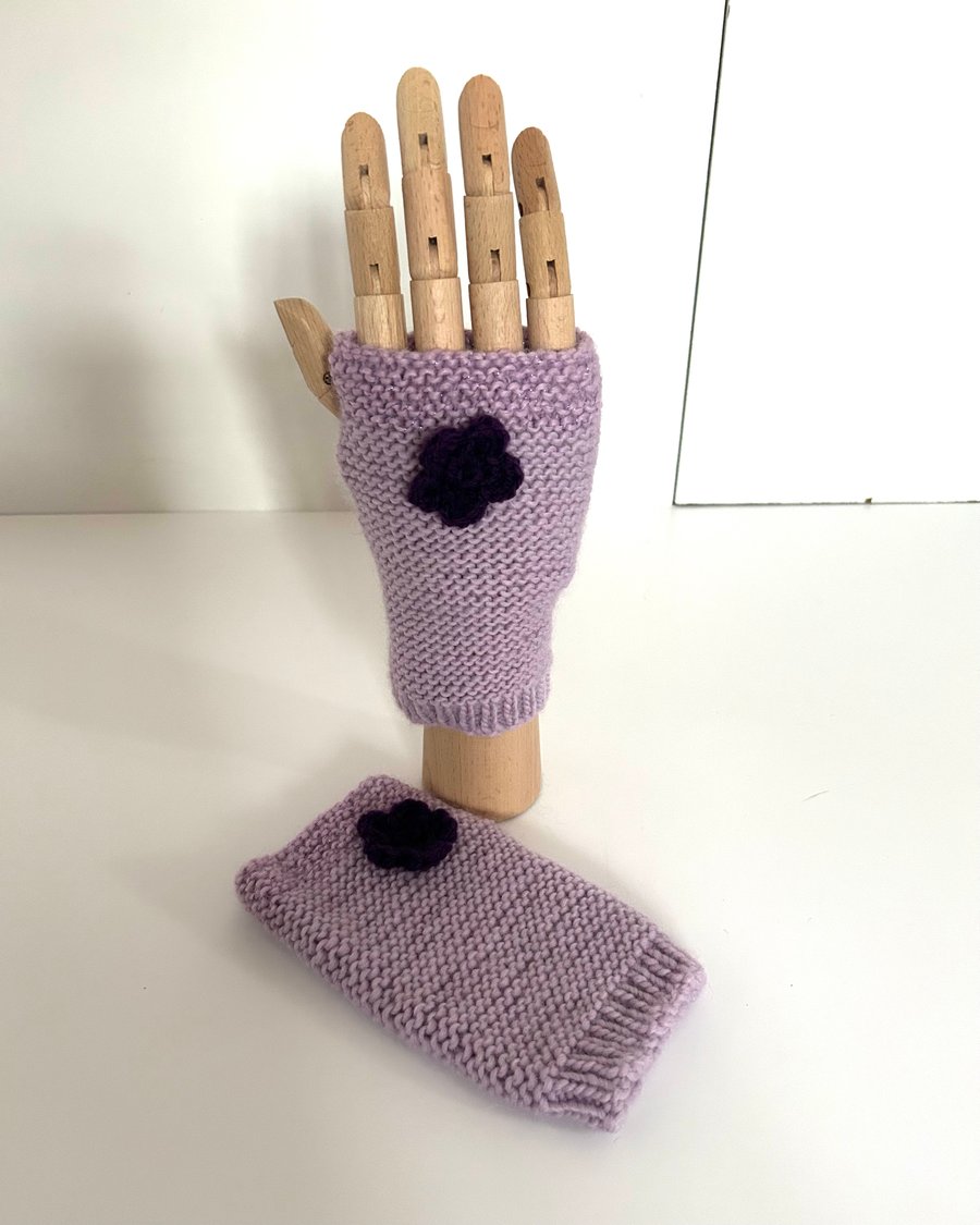 Hand knitted wrist warmers in pale purple wool with darker purple flowers
