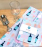 Tea towel with cut glass crystal decanters and wine glasses on light blue