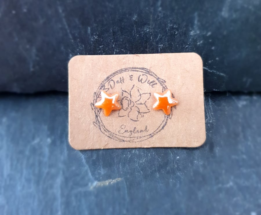 Orange Pearlized glass star stud earrings.