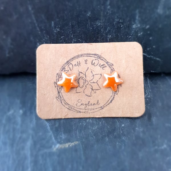 Orange Pearlized glass star stud earrings.