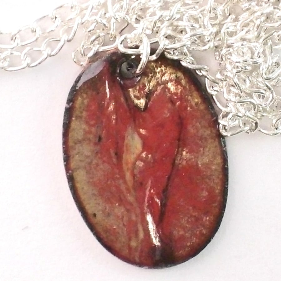 pendant - small oval:scrolled gold and black on red over clear enamel