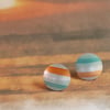 Circular stud earrings, sea and sand coloured stripes on anodised aluminium.