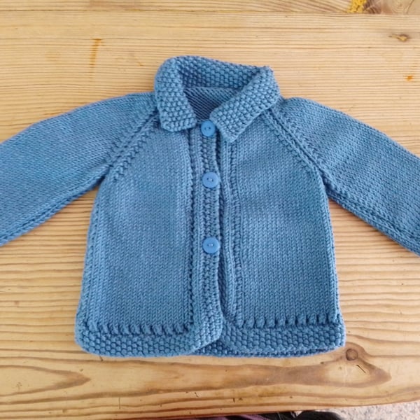 Baby cardigan handmade in denim blue merino wool to fit 3-6 months.