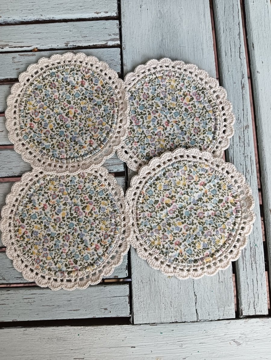 Set of four floral coasters with crochet edge.