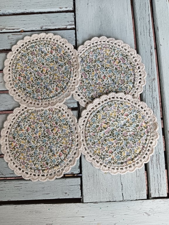 Set of four floral coasters with crochet edge.