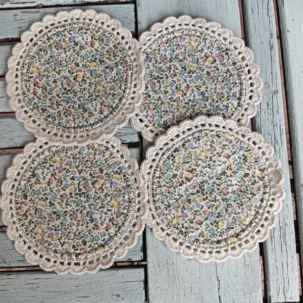 Set of four floral coasters with crochet edge.