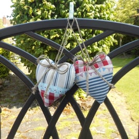 Pair hanging heart decorations on a seaside theme