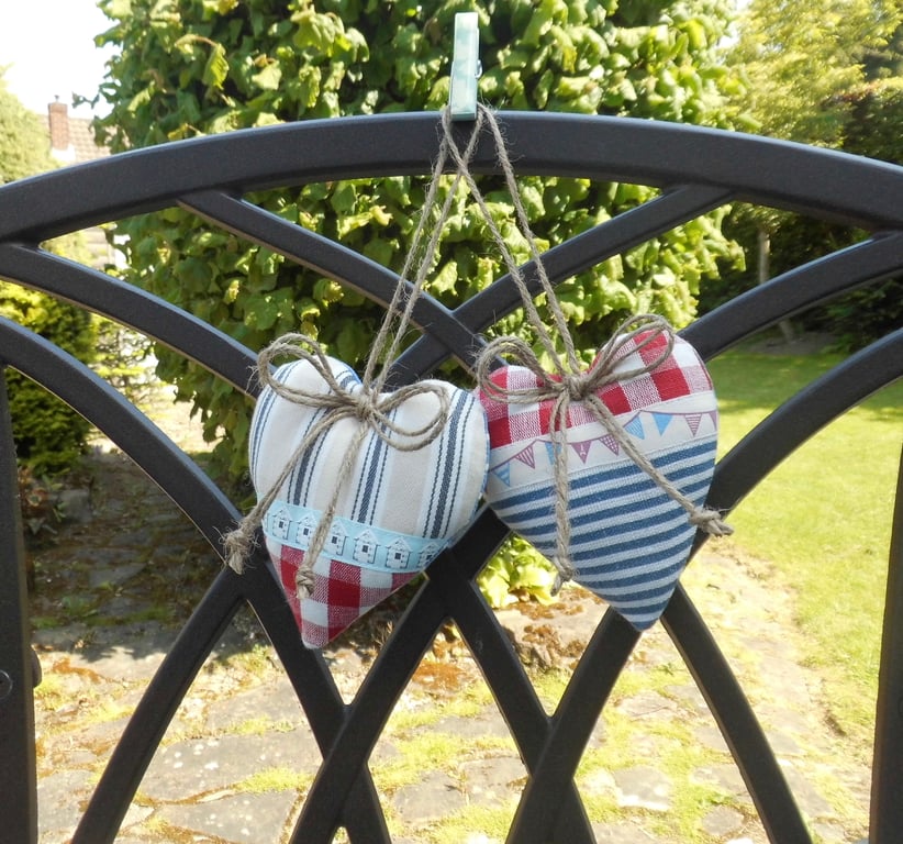 Pair hanging heart decorations on a seaside theme