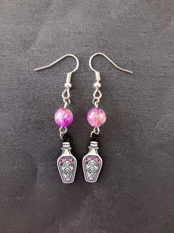 Silver poison bottle charm dangle earrings with lilac bead detail 