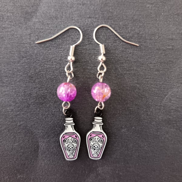 Silver poison bottle charm dangle earrings with lilac bead detail 