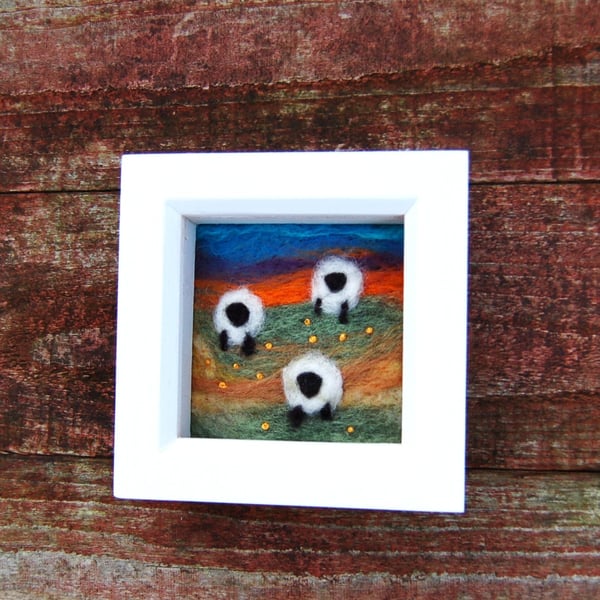 Colourful sheep wool painting.  Needlefelt picture of three sheep and flowers