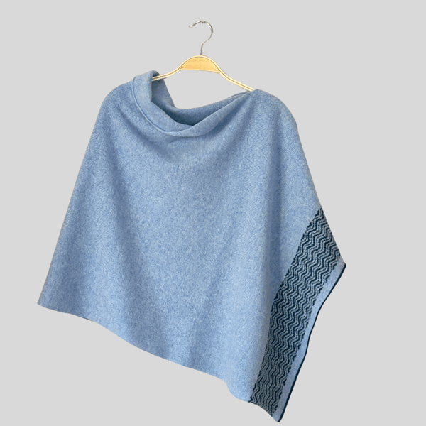 Poncho soft merino lambswool light blue with wavy petrol blue border