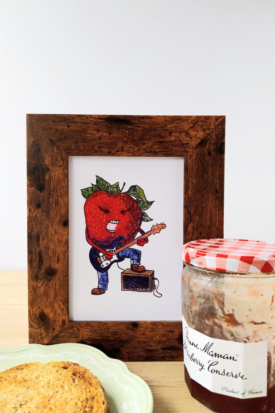 Illustration print of strawberry character playing the guitar