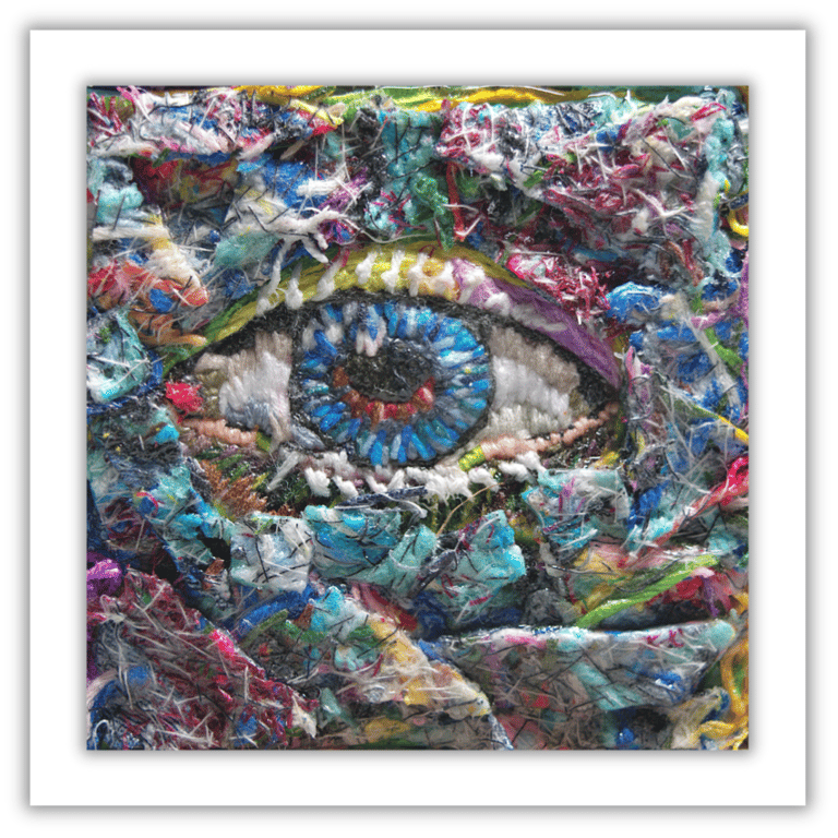 A small framed fibre artwork - needlework - eye - threads - hand stitched