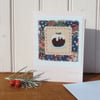 Hand-stitched pudding with embroidered details and Liberty print background
