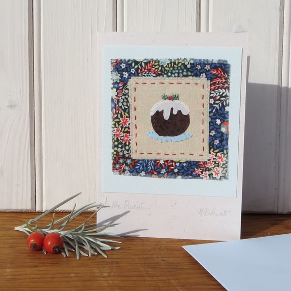 Hand-stitched pudding with embroidered details and Liberty print background