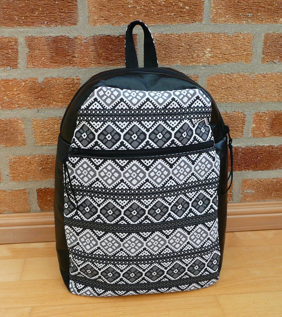 Black vinyl backpack with grey, black & white feature front panel and zip pocket