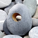 Pebble brooch with gilded hole that goes through the stone. Nature inspired.