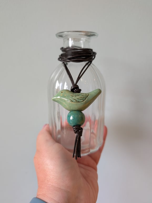 Green ceramic bird pendant on dark brown leather cord