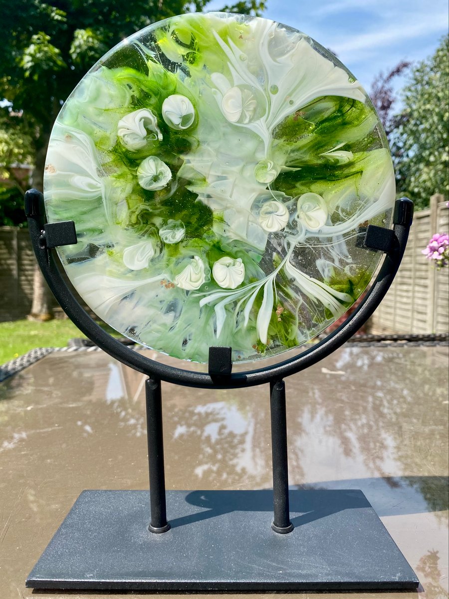 Handmade fused glass circular objet in a black metal stand