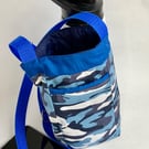 Water bottle carrier with key clip and pocket for phone. Blue camo fabric.