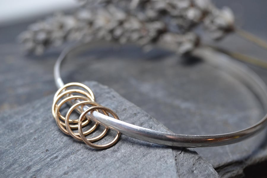Sterling silver bangle with five gold rings