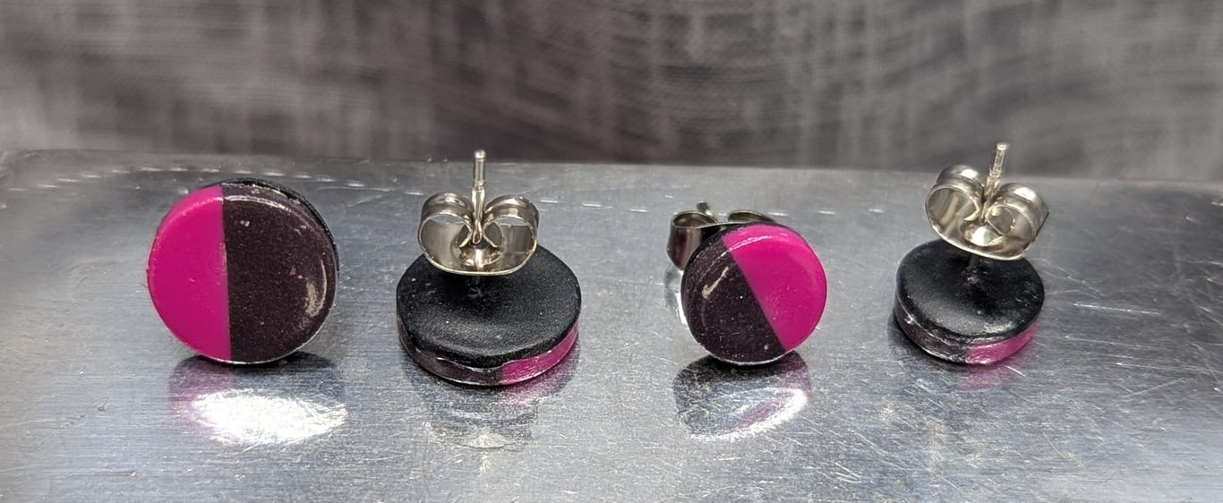 Magenta and charcoal black stud earrings.