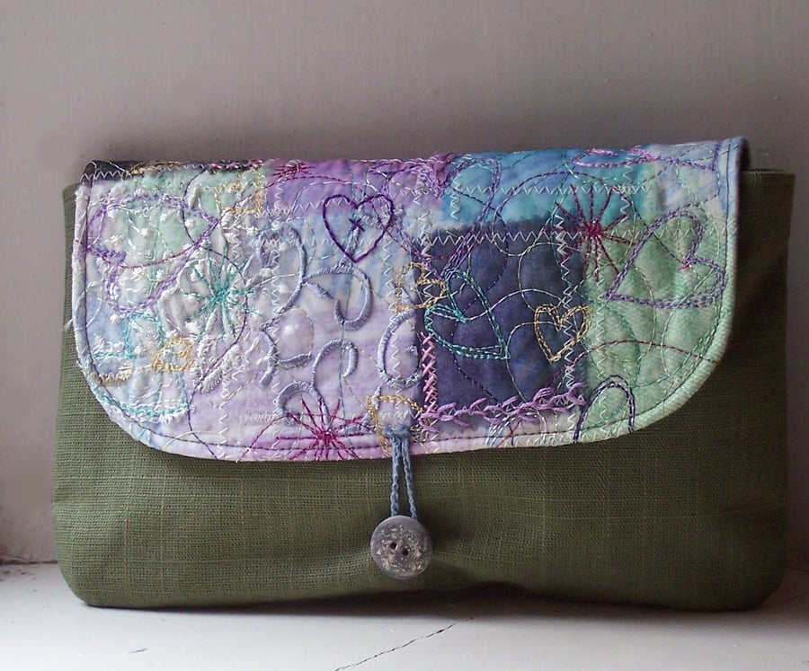 Textile art clutch bag with button and loop fastening 
