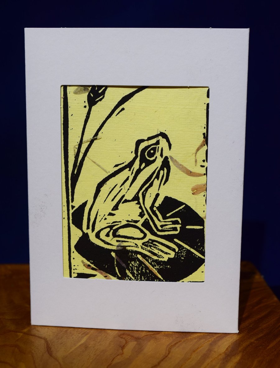 Lino print Frog on yellow paper with petal texture