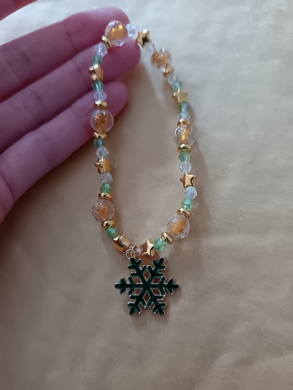 Elasticated beaded green and gold star bracelet with snowflake charm 