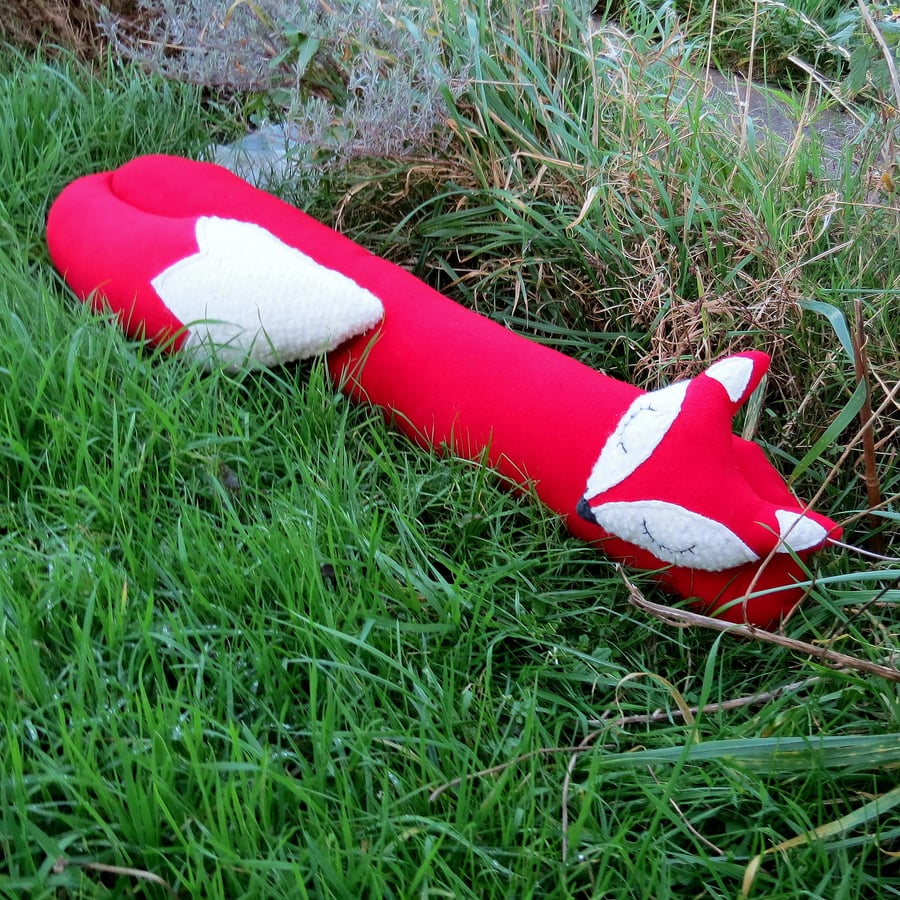 A snoozy fox draught excluder.  Big red fox.  Winter.