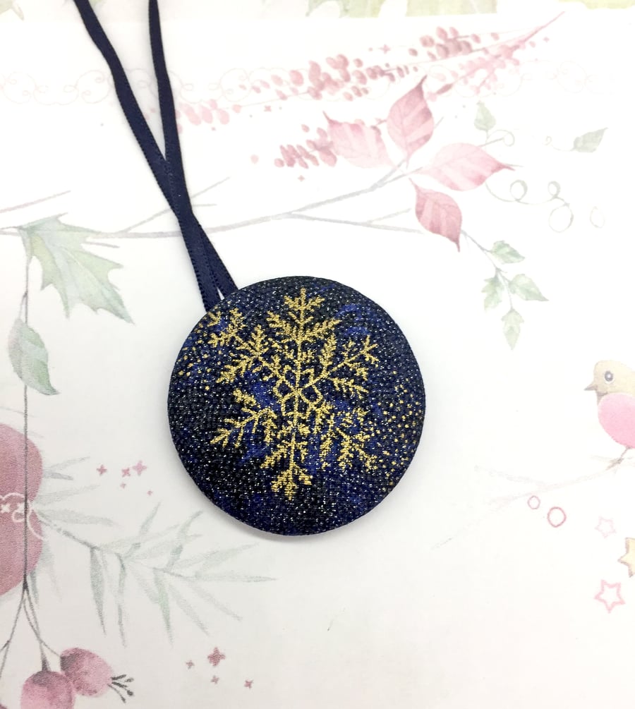 Gold snowflake on glittery blue background fabric button hanging ornament