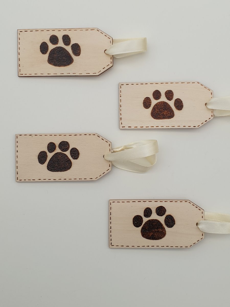 Woodburned paw print wooden tags or labels decorated using pyrography 