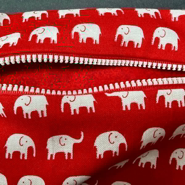 Small funky zipped pouch with white elephants on scarlet red background