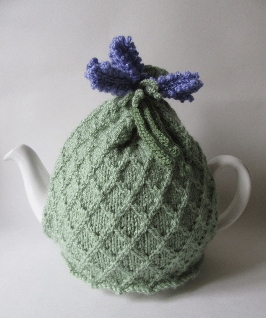 Knitted pastel green tea pot cosie with lavender flowers