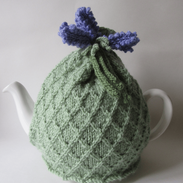 Knitted pastel green tea pot cosie with lavender flowers