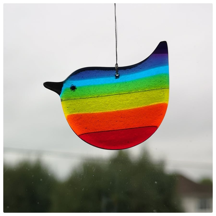 A rainbow wren of hope glass bird with a dark purple tipped tail