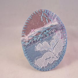 Hand embroidered fabric brooch in delicate, frosty shades